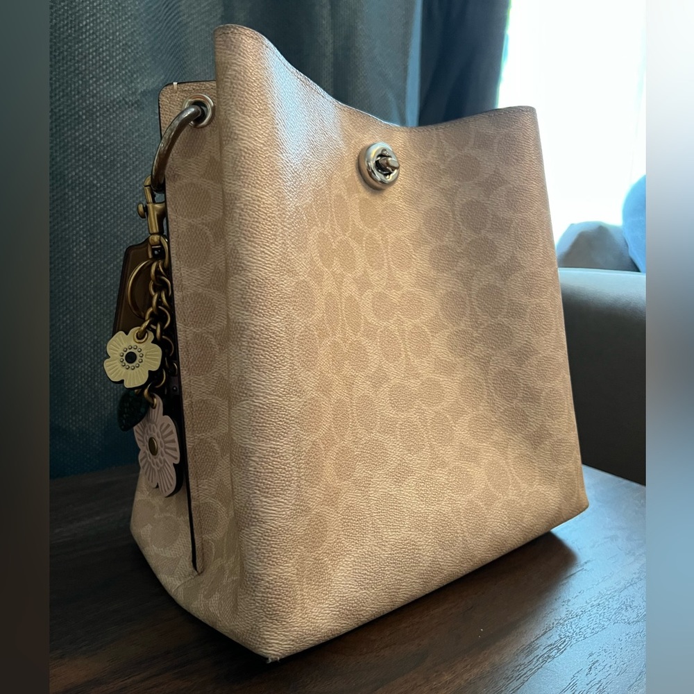 Coach bag with flower key chain accessory.